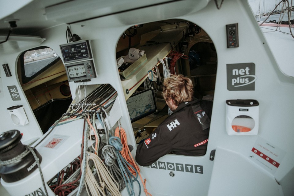 Route du Rhum 2022 - Luke Berry dans la cabine du bateau, en train de regarder les cartes météo - Lamotte